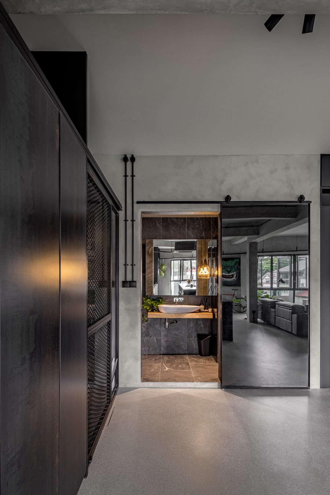 A doorway to the guest bath — a timber-shelf basin behind a steel sliding door