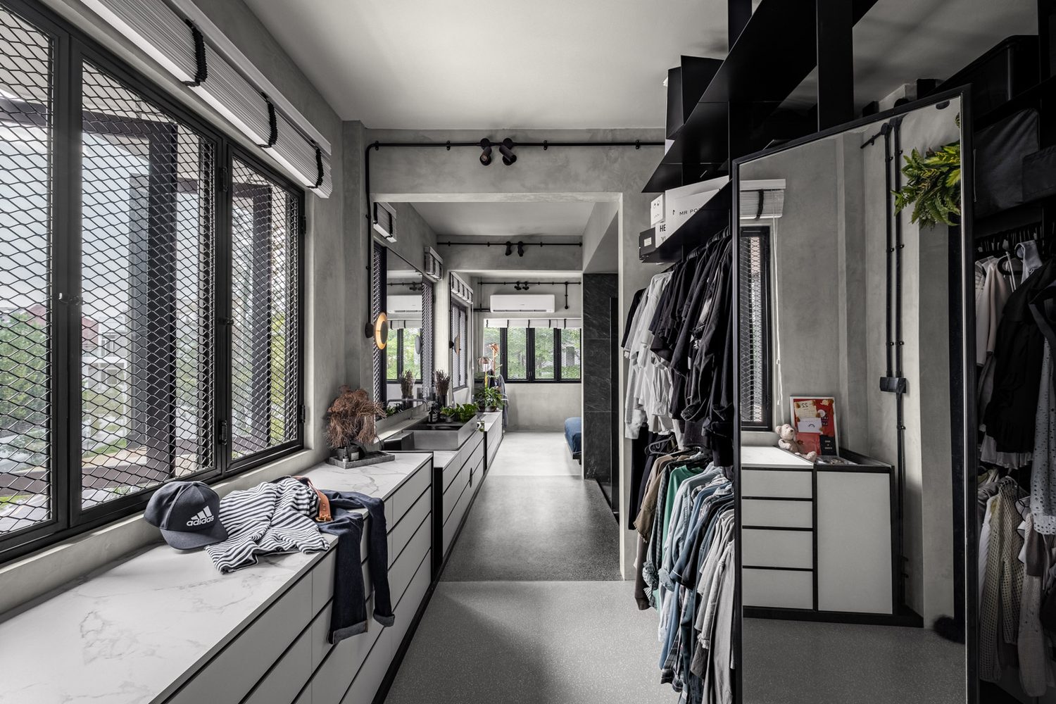 The walk-in wardrobe — open rails and marble-topped drawers under mesh windows