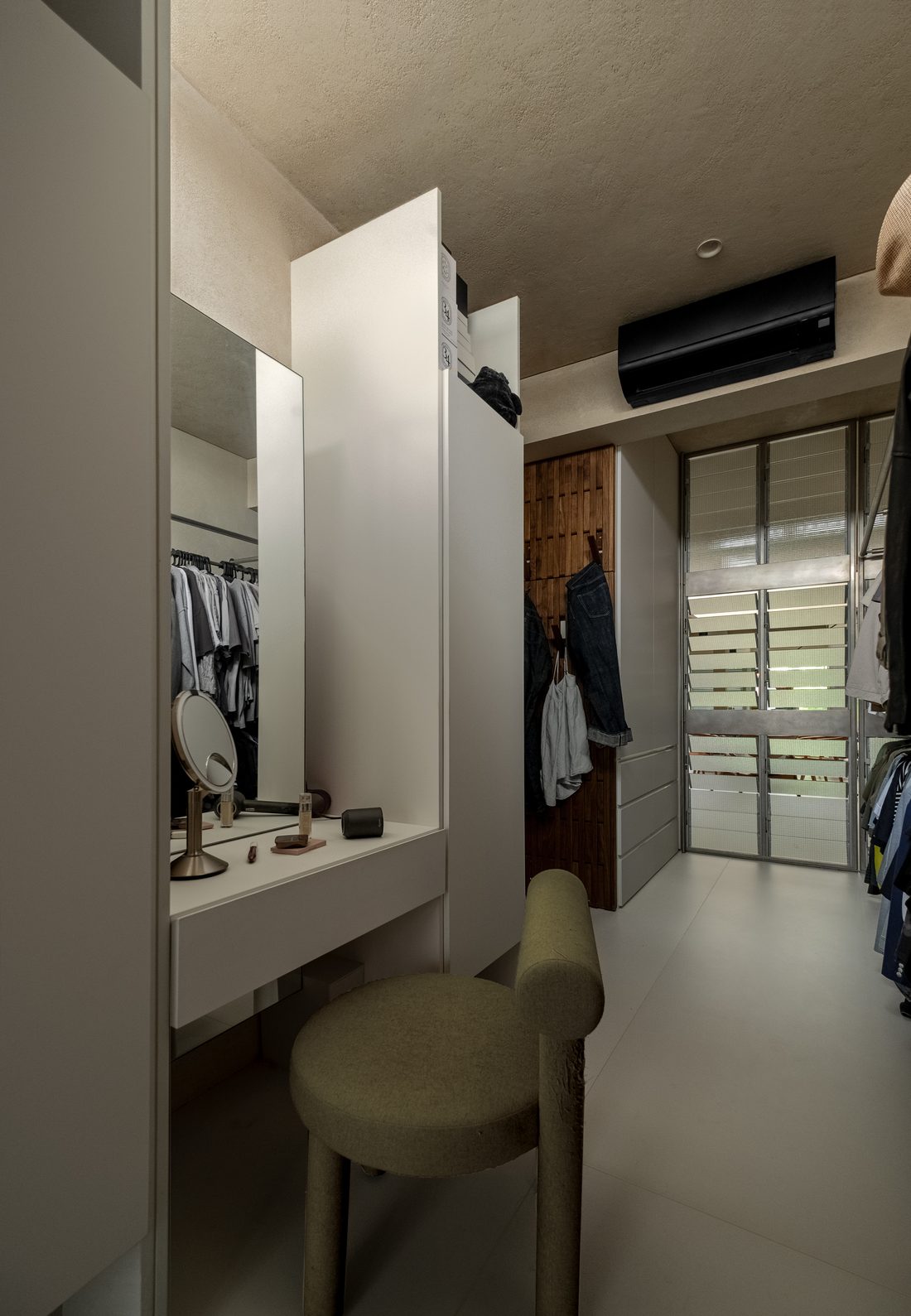 The dressing room — a mirrored vanity and open wardrobe in soft white