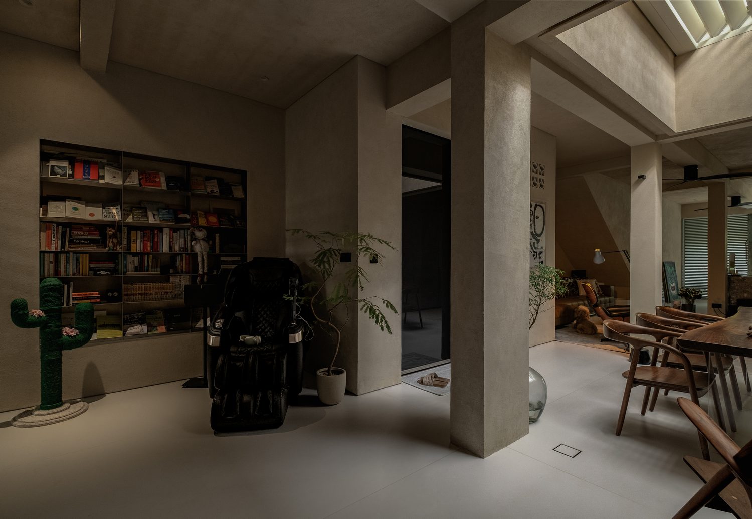 The library landing — a full-height bookcase beside the skylit living spaces