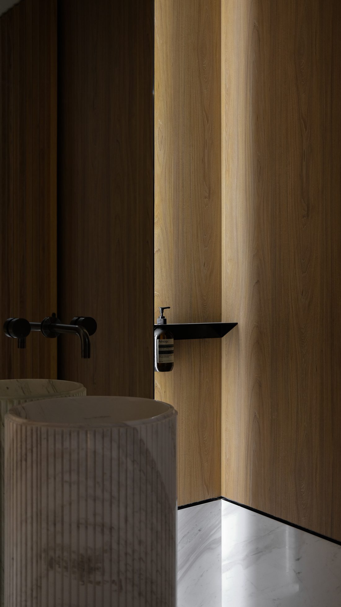 A detail — the fluted basin and a slim black shelf on timber
