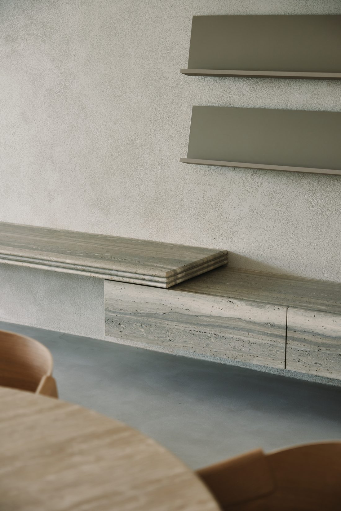 The travertine credenza and wall shelves, seen at an angle