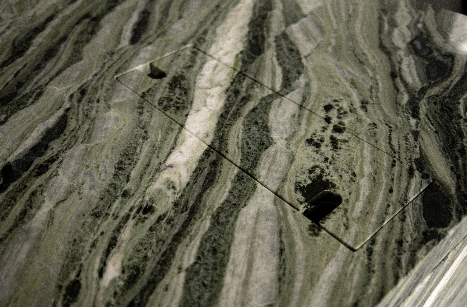 A close view of the green marble, its veining running diagonally across the surface